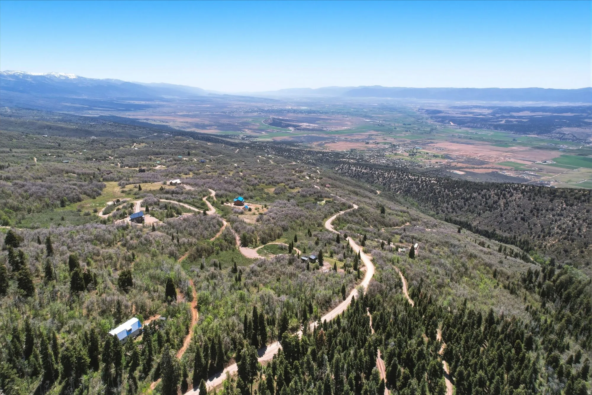 Expansive mountainous terrain featuring scattered residential structures