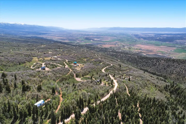Expansive mountainous terrain featuring scattered residential structures
