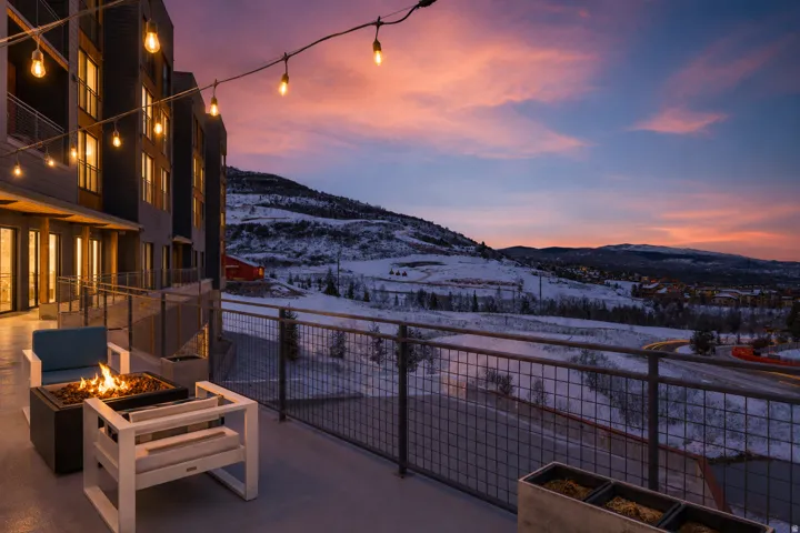 Expansive outdoor patio area featuring string lighting and a built-in fire pit