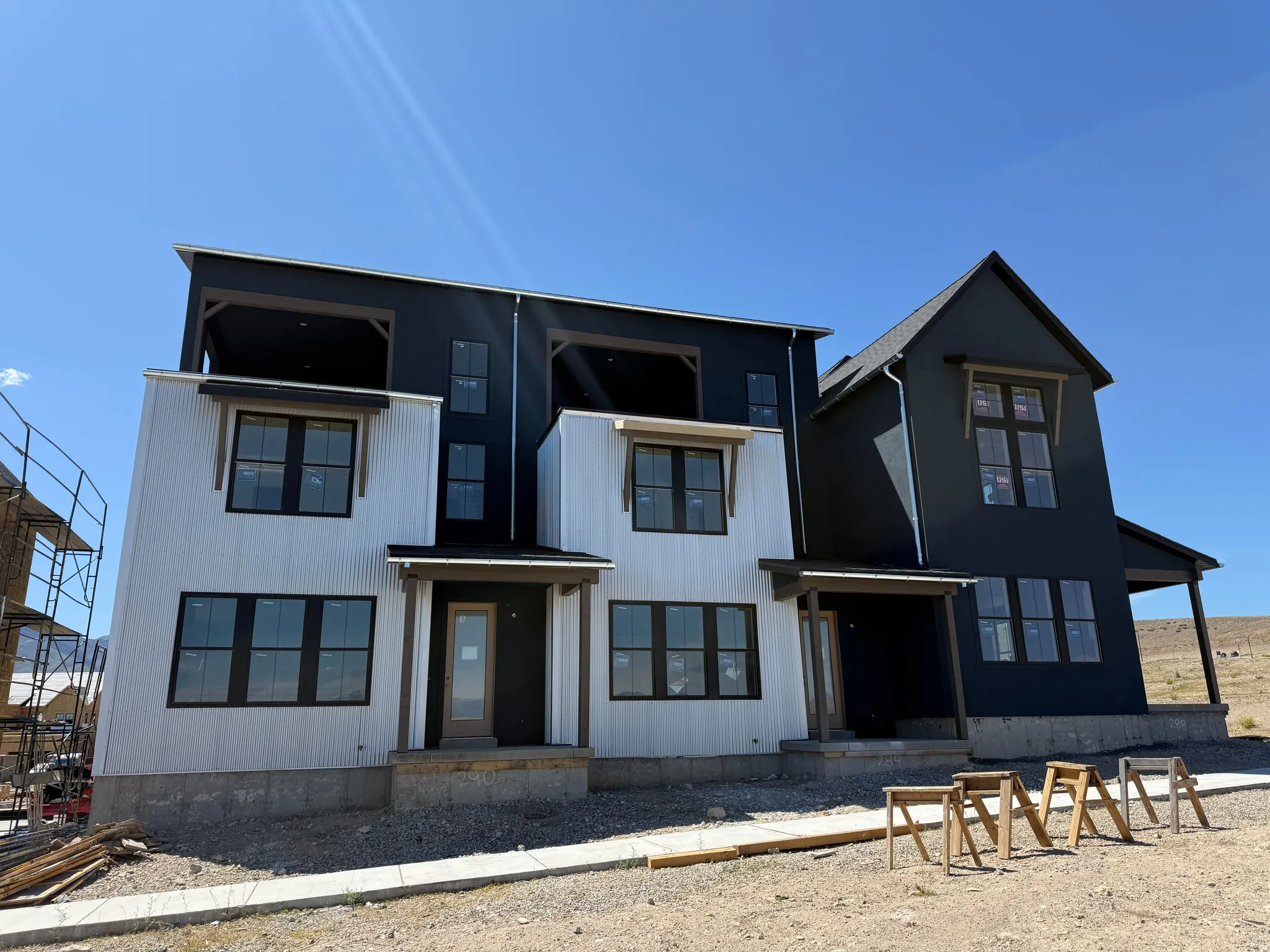 Modern farmhouse-inspired exterior with white corrugated siding and dark vertical siding accents