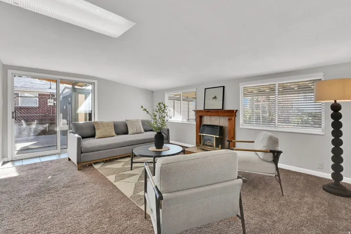 Living area with neutral tone carpet and light gray walls