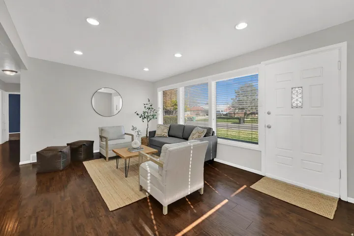 Living area featuring extensive wood-finish flooring, recessed lighting, and a front entry door with decorative glass inserts