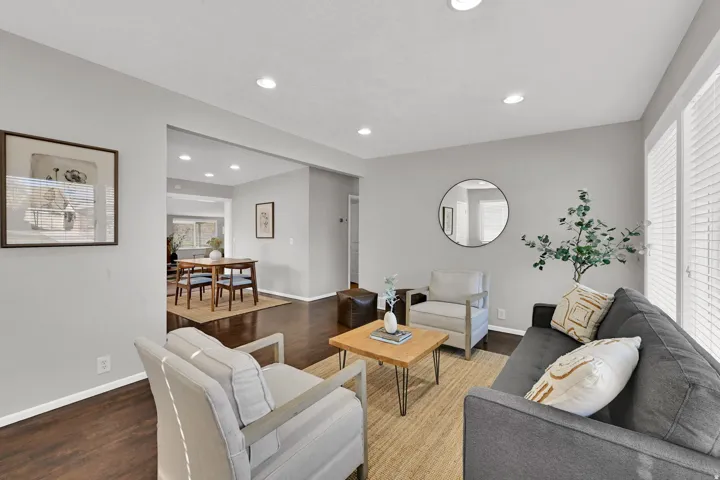 Living area featuring dark wood-finish flooring, recessed lighting, and white baseboards