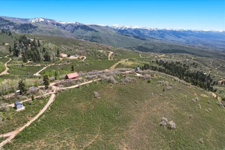 Expansive mountain terrain featuring a diverse landscape of evergreen forests and verdant hills