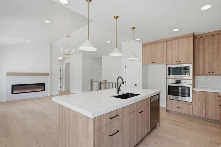 Kitchen island with white countertop, integrated black sink, and matte black faucet