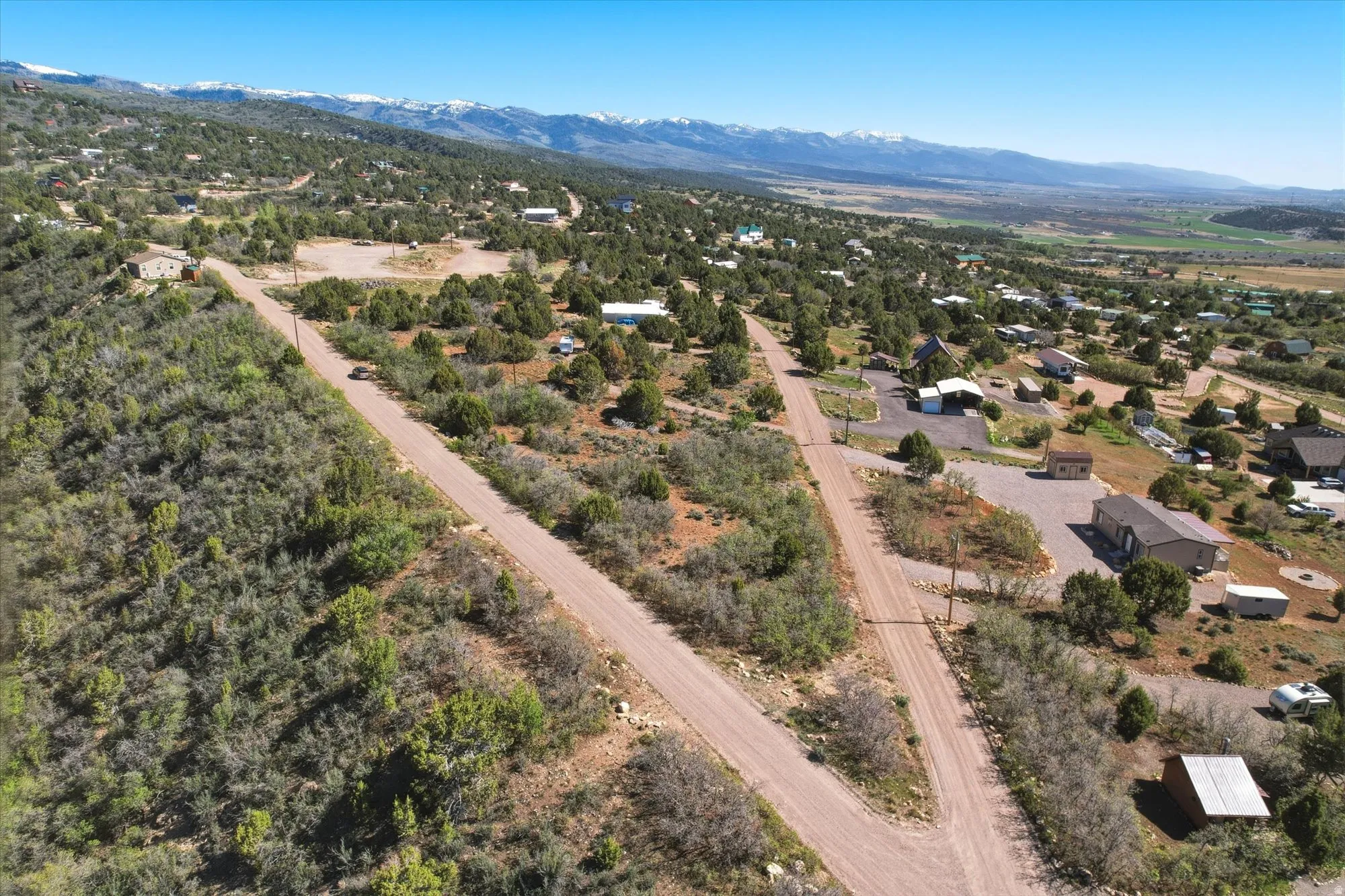 Expansive land parcel with unpaved road frontage, surrounded by natural vegetation
