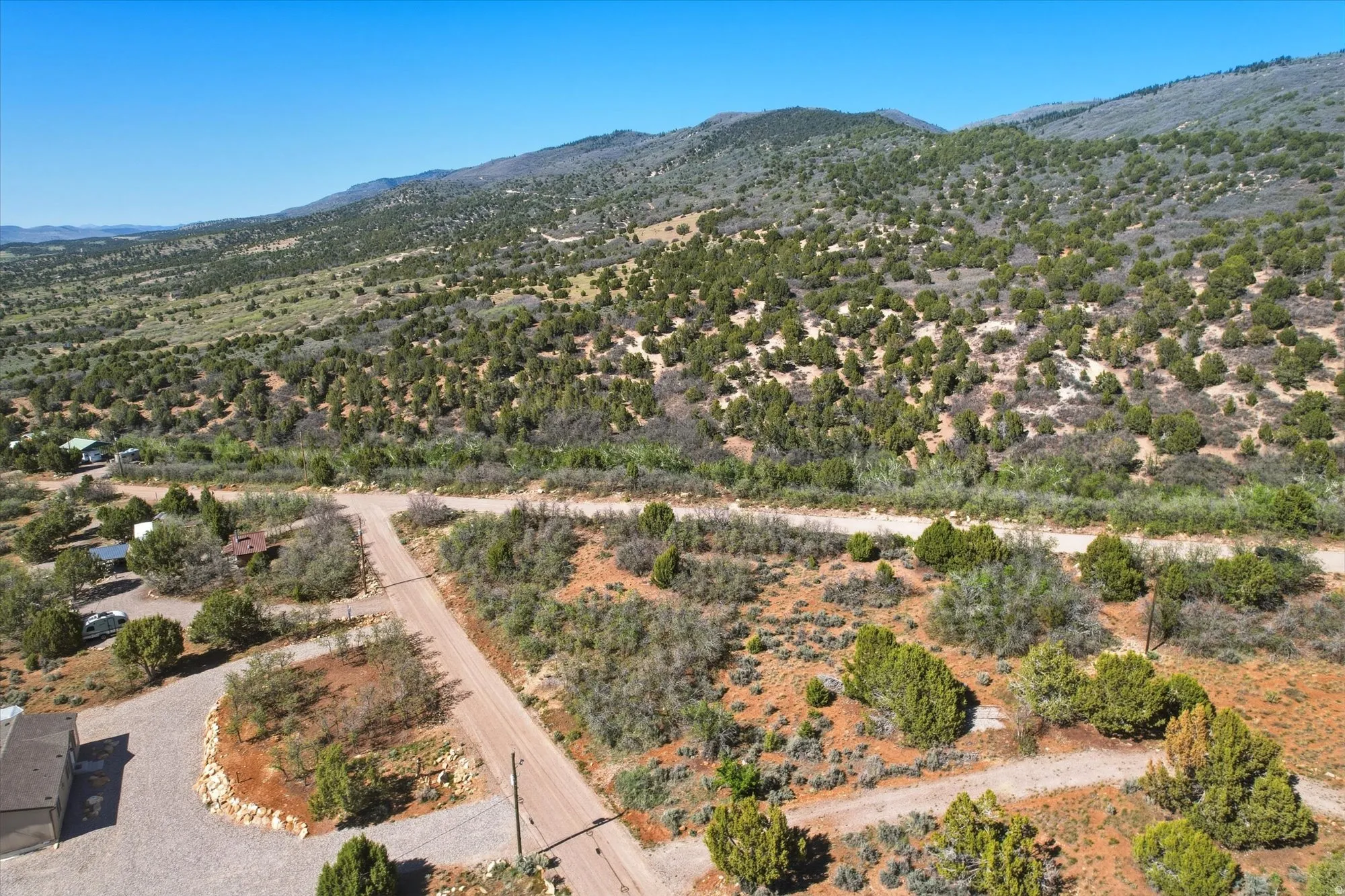 Expansive mountain landscape featuring varied terrain and natural vegetation under a clear sky