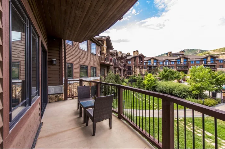 Private balcony with a metal railing, overlooking a landscaped green space
