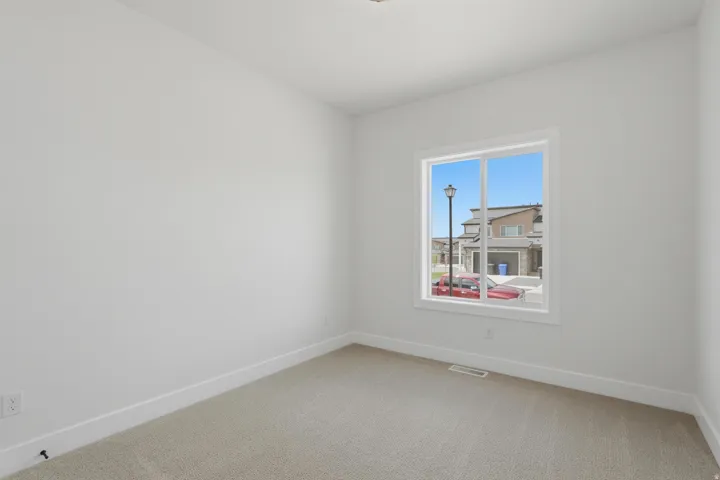 Spacious room featuring neutral carpeting and white painted walls