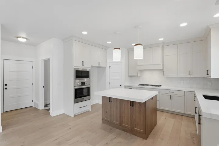 Modern kitchen featuring a central island with wood-finish cabinetry and a white countertop