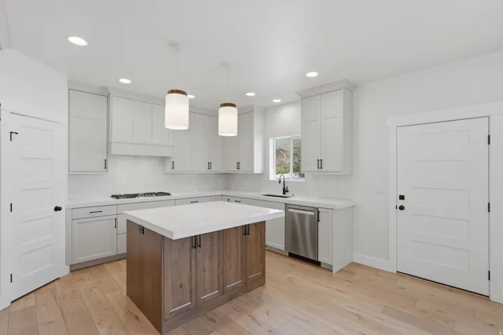 Kitchen featuring light wood-finish flooring and a central island with a light-toned countertop