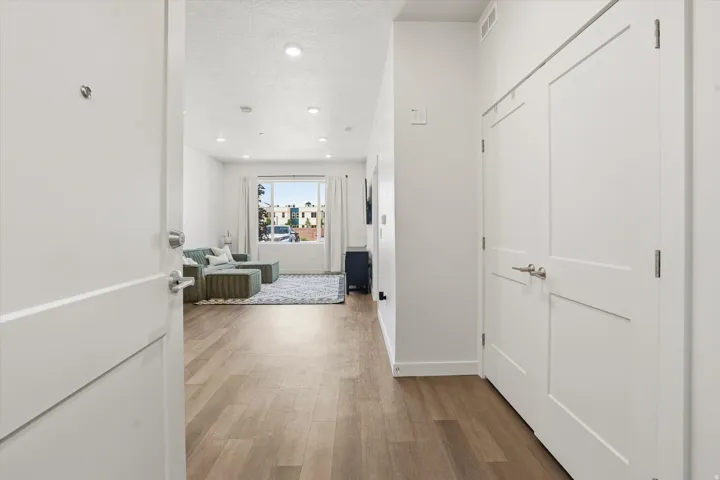 Entryway featuring wood-finish flooring, recessed lighting, and a white interior door with contemporary hardware