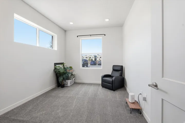 Room featuring light gray carpeting, crisp white walls, and a recessed ceiling light