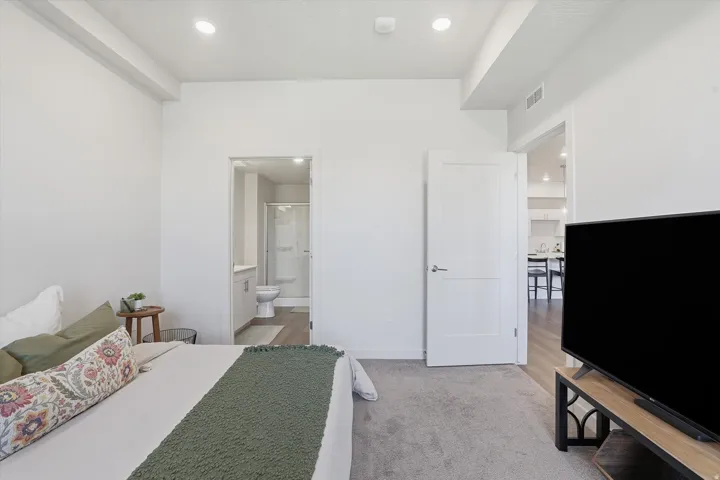 Spacious room featuring light-colored walls and grey carpeting