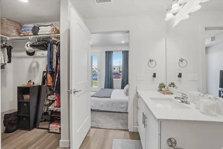 Bathroom vanity with a white countertop and integrated sink, chrome faucet, and expansive mirror