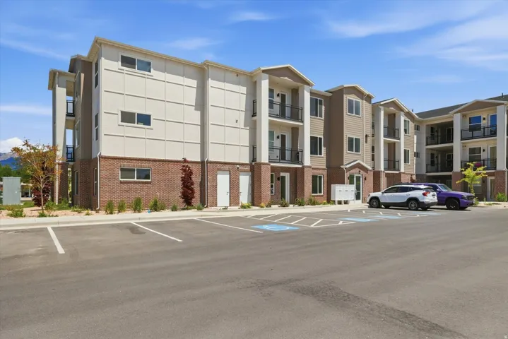 Multi-story building featuring a brick base and neutral-toned siding