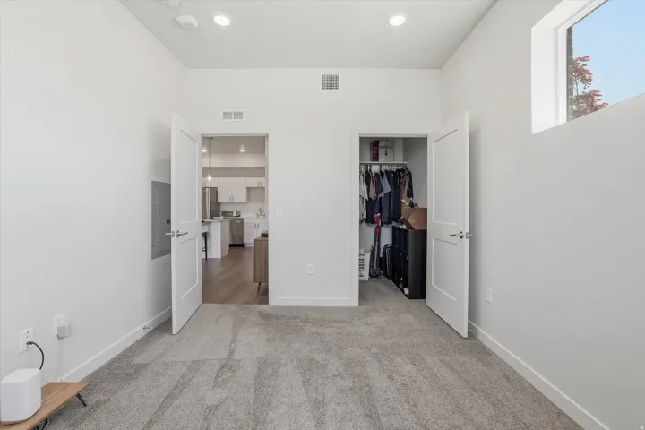 Carpeted room with recessed lighting and a high transom window