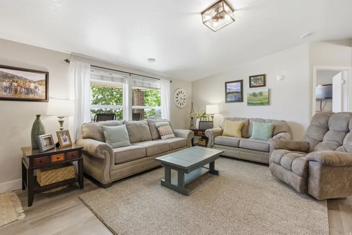 Living area featuring light-colored walls, a textured ceiling, a large window, and a rectangular ceiling light fixture