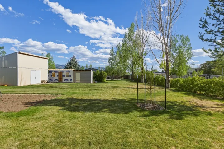 Expansive green space featuring established trees and a defined garden area