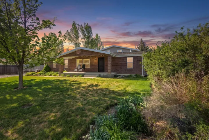 Brick exterior residence with a covered front porch and mature landscaping