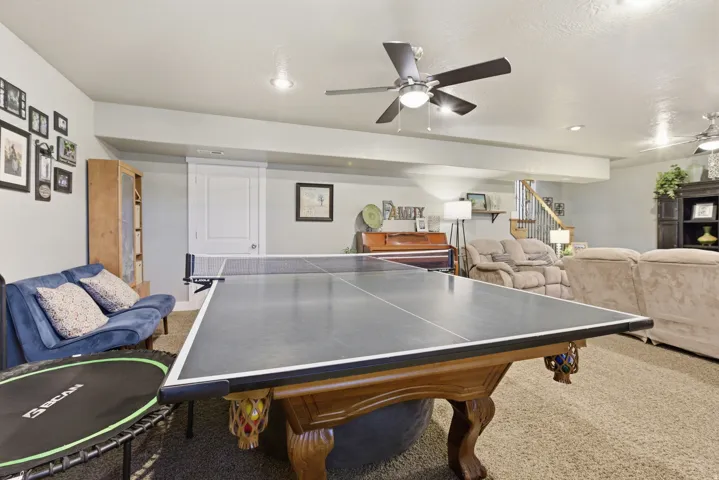 Spacious lower-level area with recessed lighting, ceiling fan fixtures, and carpeted flooring