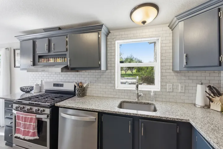 Kitchen featuring a stainless steel gas range, dishwasher, and sink