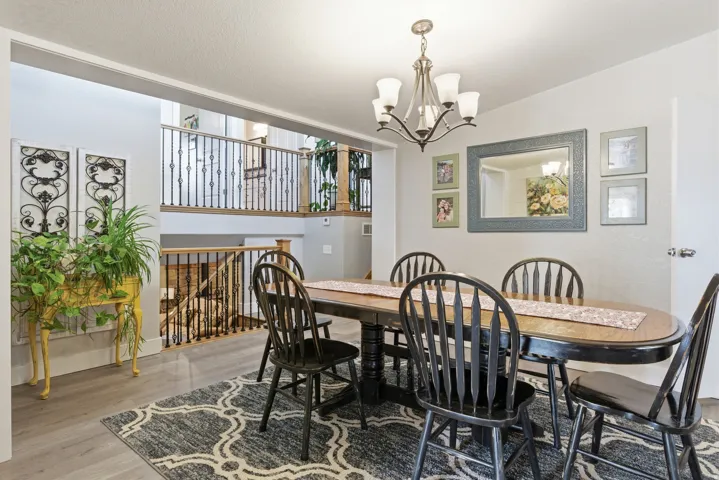 Dining area with wood-finish flooring and a central chandelier