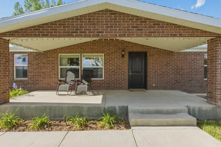 Brick exterior with a covered concrete porch, concrete steps.