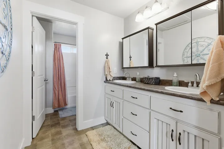 Dual vanity with white cabinetry and dark hardware