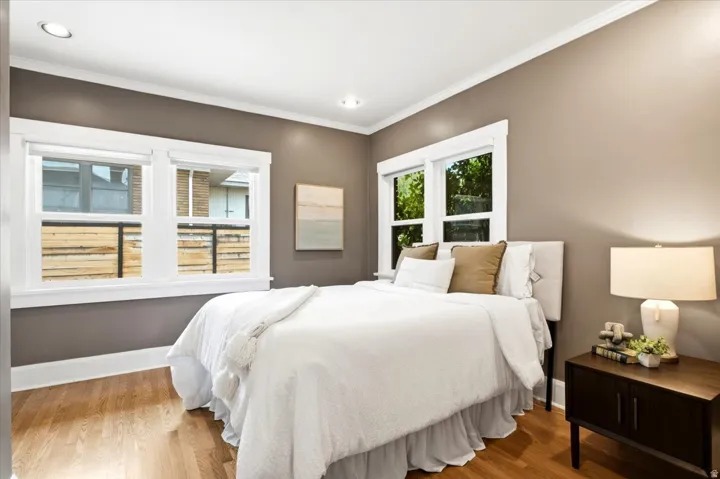 Hardwood-finish flooring, recessed lighting, crown molding, and multiple windows with white trim