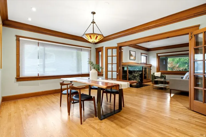 Hardwood flooring, wood trim and crown molding, recessed lighting, and a chandelier with a glass shade