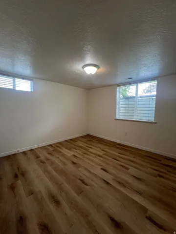 Bedroom 2 with LVP flooring, fresh white walls, and two windows with blinds