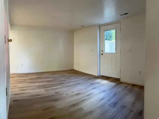 Living Room with LVP flooring with neutral wall tones and a white exterior door