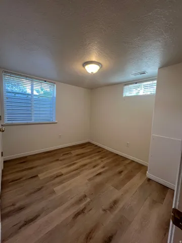 Bedroom 1 with LVP flooring with white trim and new wall paint