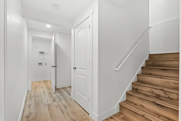 Hardwood stairs with a white handrail