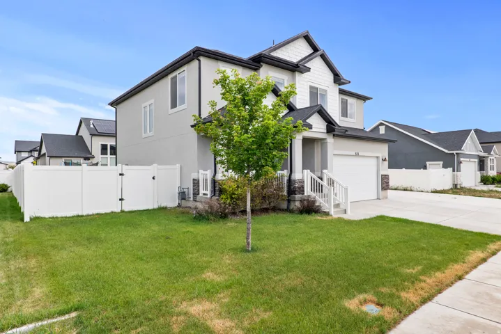 Contemporary two-story residence featuring a white and gray exterior, an attached single-car garage, and a concrete driveway