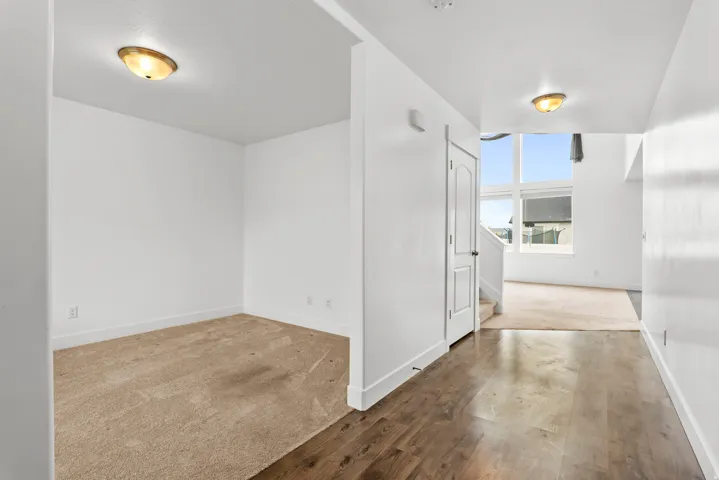 Entryway featuring wood-finish flooring, white trim, and a white interior door