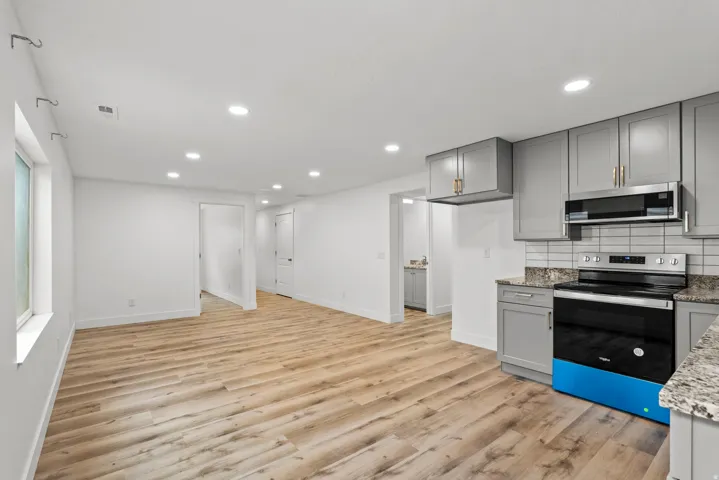 Open-concept space featuring wood-finish flooring, recessed lighting, and a kitchen area