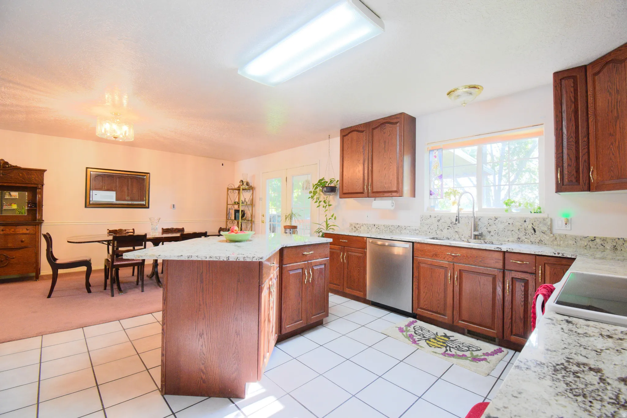 Kitchen featuring a central island with countertop seating, wood cabinetry, granite countertops, and stainless steel appliances
