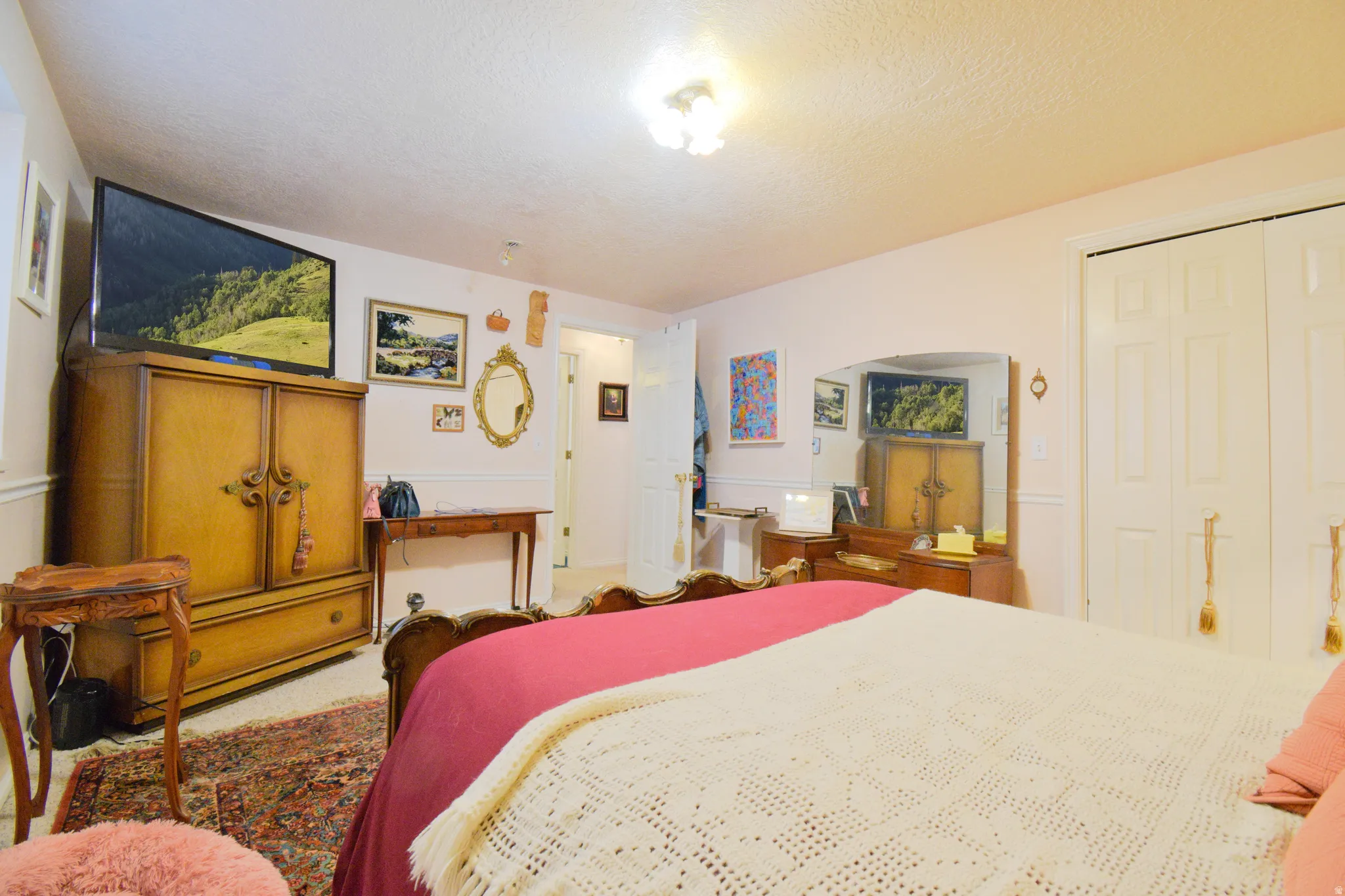 Carpeted room featuring light pink walls with white wainscoting