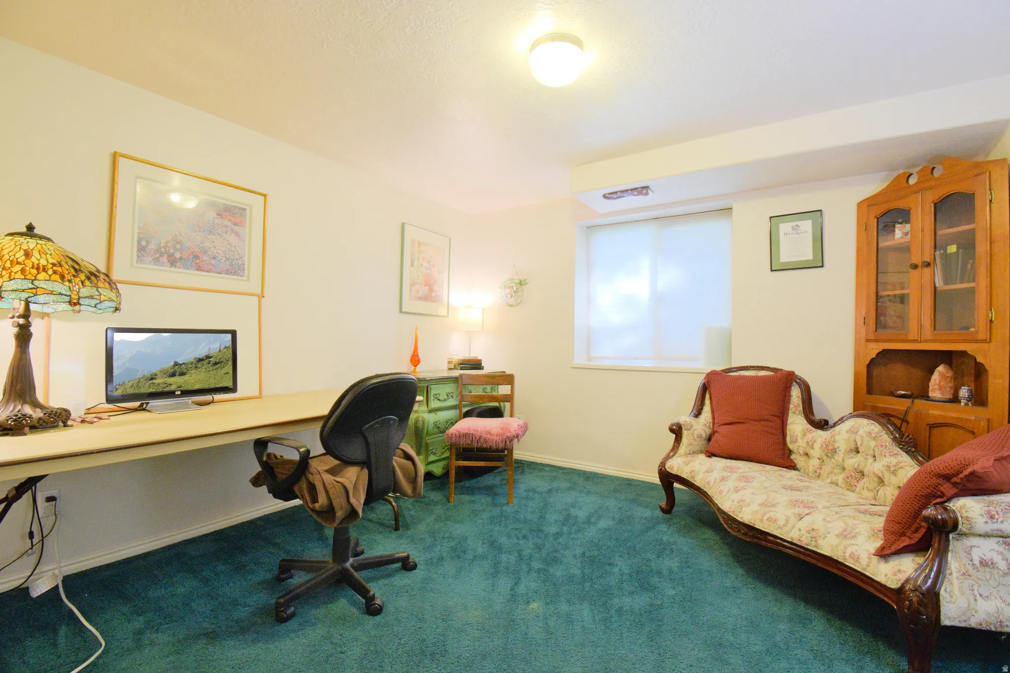 Room featuring wall-to-wall carpeting, light-colored walls, and a built-in desk