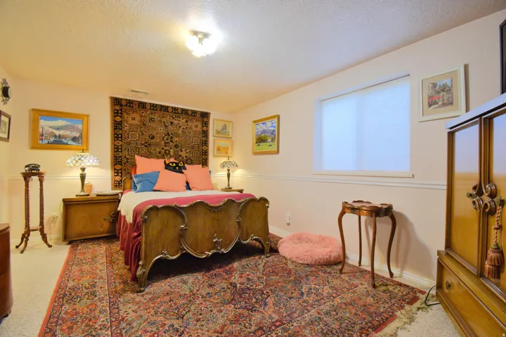 Windowed room with a textured ceiling, painted walls with wainscoting, and carpet flooring
