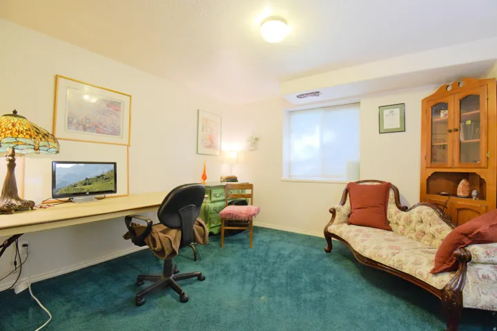 Room featuring wall-to-wall carpeting, light-colored walls, and a built-in desk