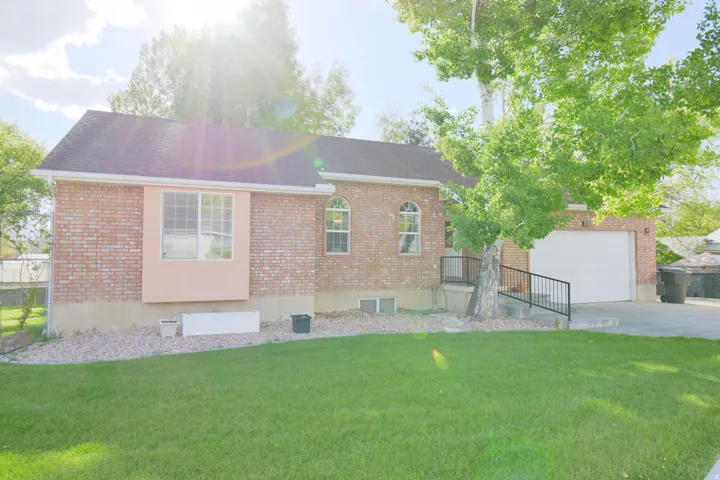 Brick exterior featuring a bay window, arched window details, and a concrete driveway