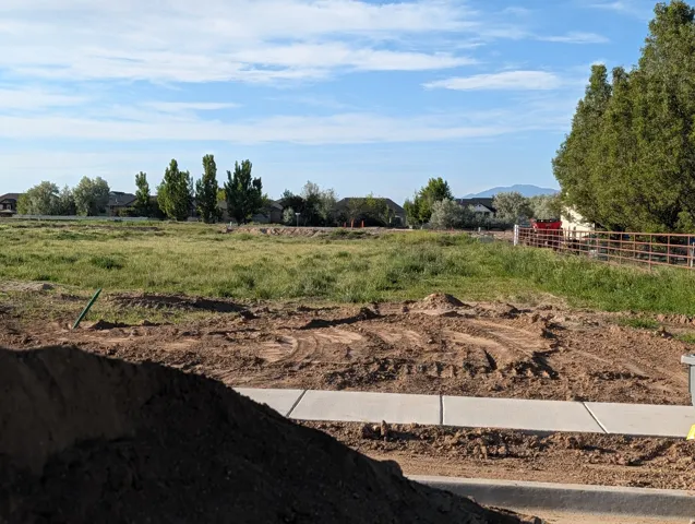 Expansive land parcel featuring existing concrete sidewalks and a clear, level building area