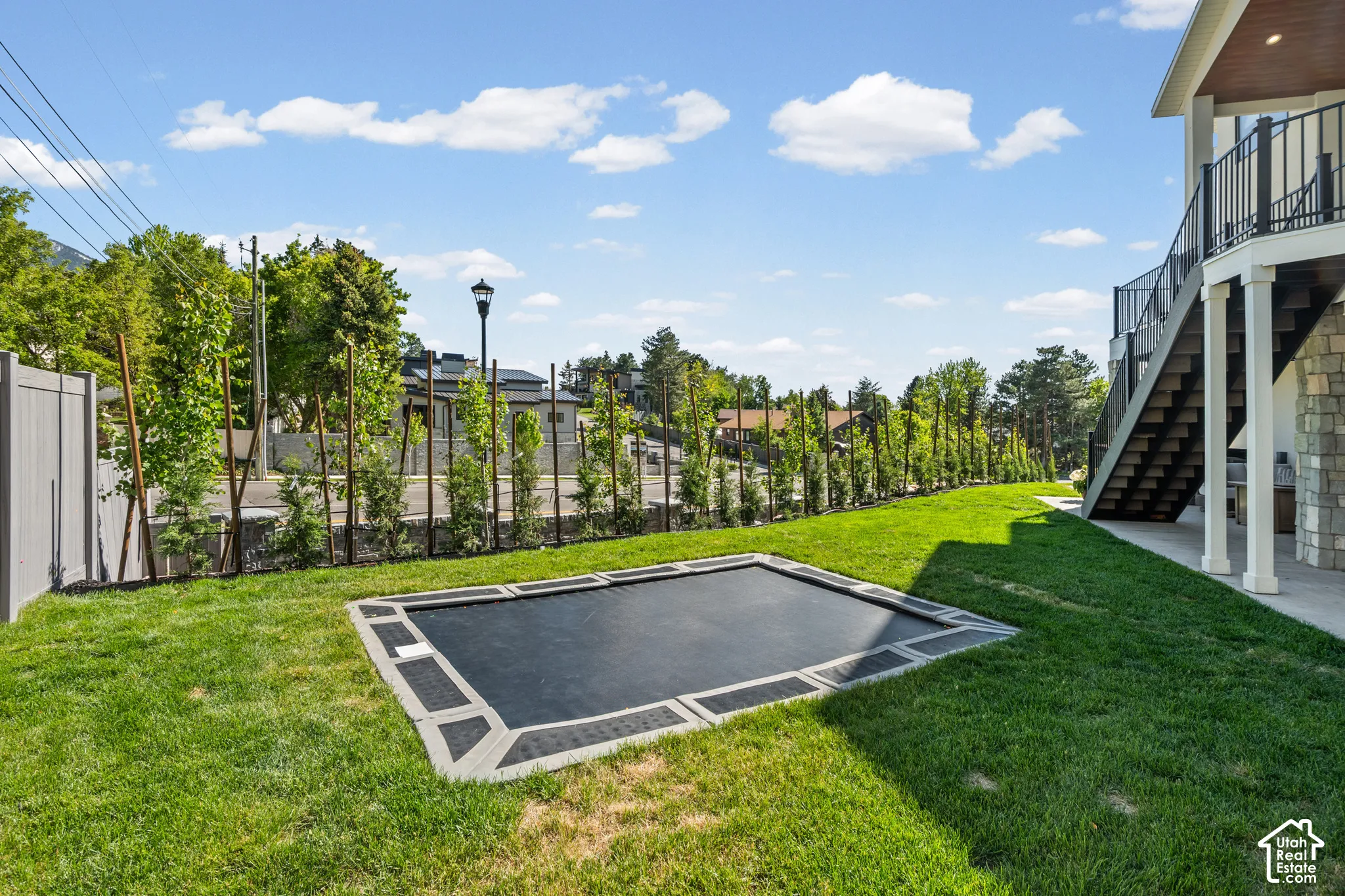 Expansive turf lawn featuring an in-ground trampoline