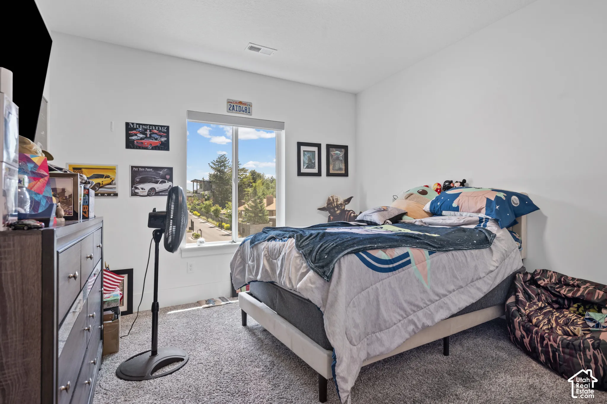 Bright room featuring a large window, plush carpet flooring, and neutral wall paint