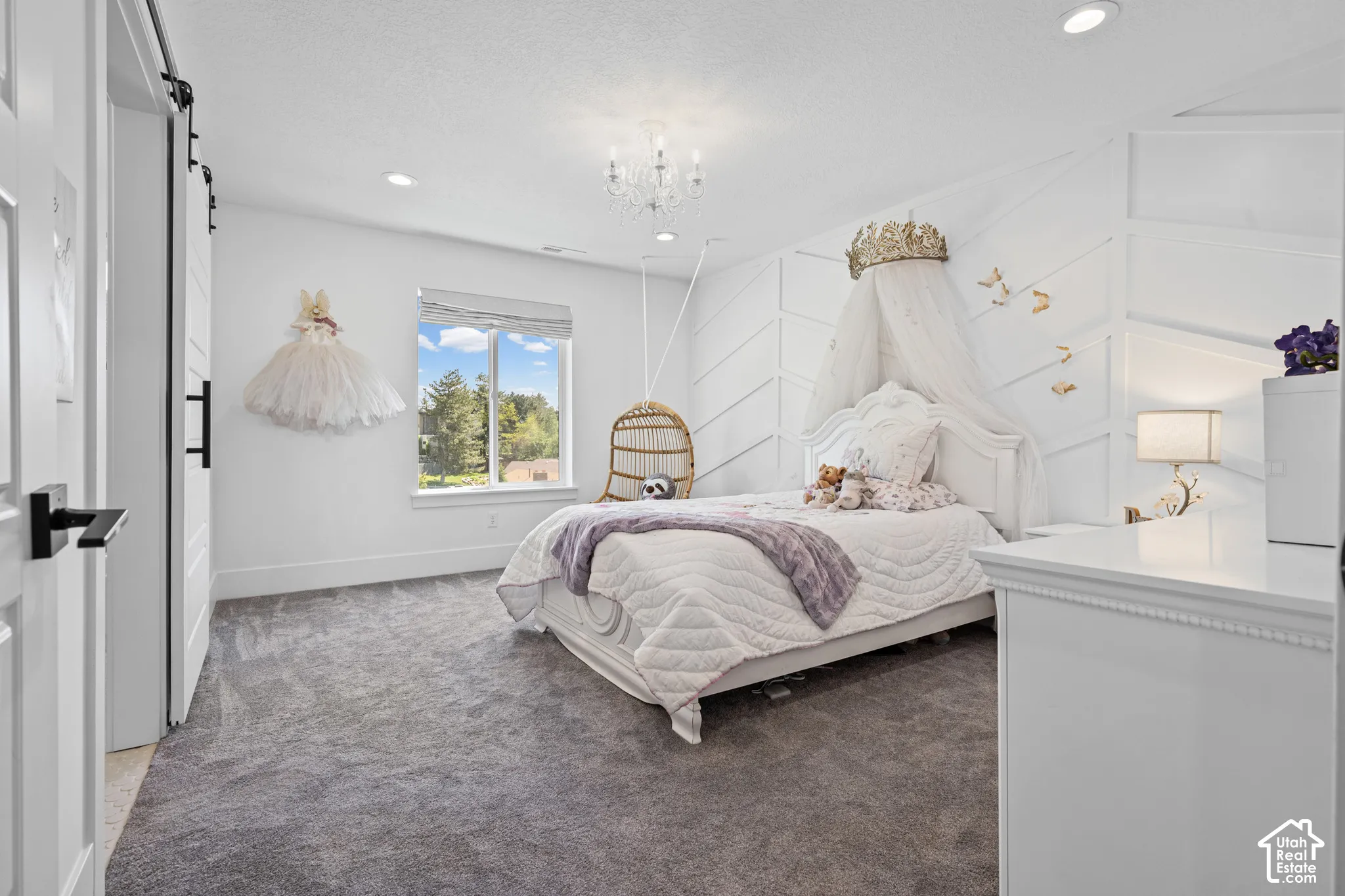 Spacious room featuring plush gray carpeting and a prominent window