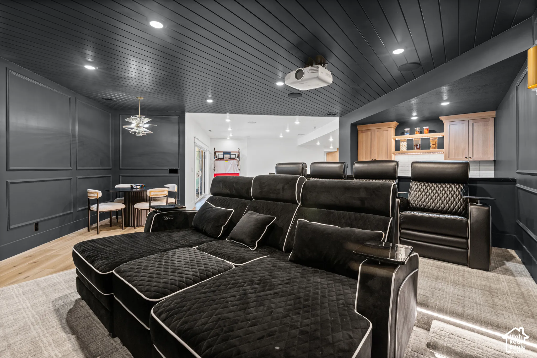 Dedicated media room featuring a dark shiplap ceiling, recessed lighting, and wall paneling