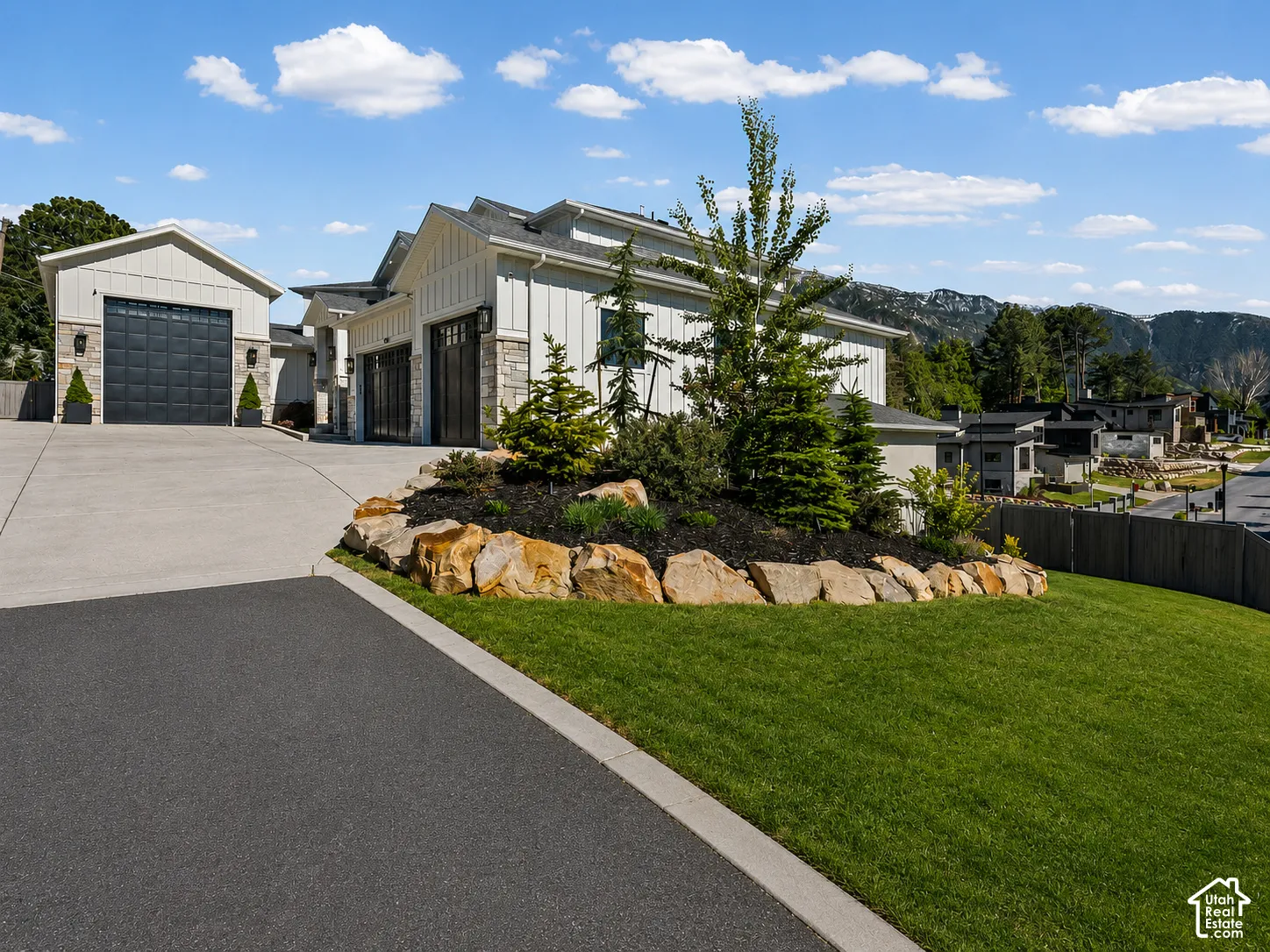 Modern home exterior featuring vertical white siding and stone accents